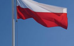 Biało czerwona flaga powiewa na tle nieba