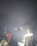 Dwóch strażaków stojących w dymie