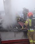 Czterech strażaków rozbiera dymiący dach