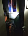 Pokój oświetlony latarką z otwartym oknem, brudny po po pożarze