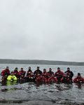 Strażacy w suchych skafandrach pozuje do zdjęcia grupowego w wodzie na tle Zalewu Koronowskiego