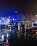 Dwa uszkodzone samochody pomiędzy dwoma wozami strażackimi w nocy, przy samochodzie cywil i dwóch strażaków.