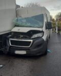 Bus ma rozbitą maskę i szybę, przód auta jest rozbity o tył naczepy innego auta. W tle widać 3 strażaków