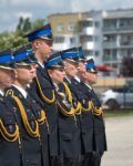 Funkcjonariusze w mundurach wyjściowych stoją w szeregu na placu apelowym