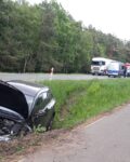 5 W przydrożnym rowie stoi rozbite auto, w tle droga na której stoją auta.
